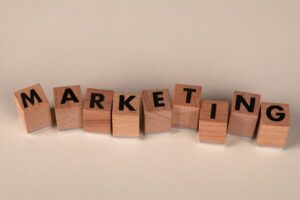 קוביות עץ מאויתות 'MARKETING' על משטח בהיר